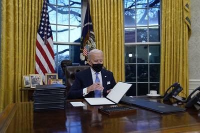 President Joe Biden signs his first executive orders in the Oval Office of the White House on Wednesday, Jan. 20, 2021, in Washington.