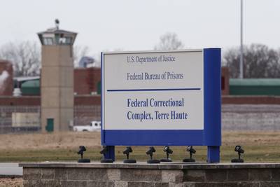 In this Dec. 10, 2019, file photo the guard tower flanks the sign at the entrance to the U.S. Penitentiary in Terre Haute, Ind.