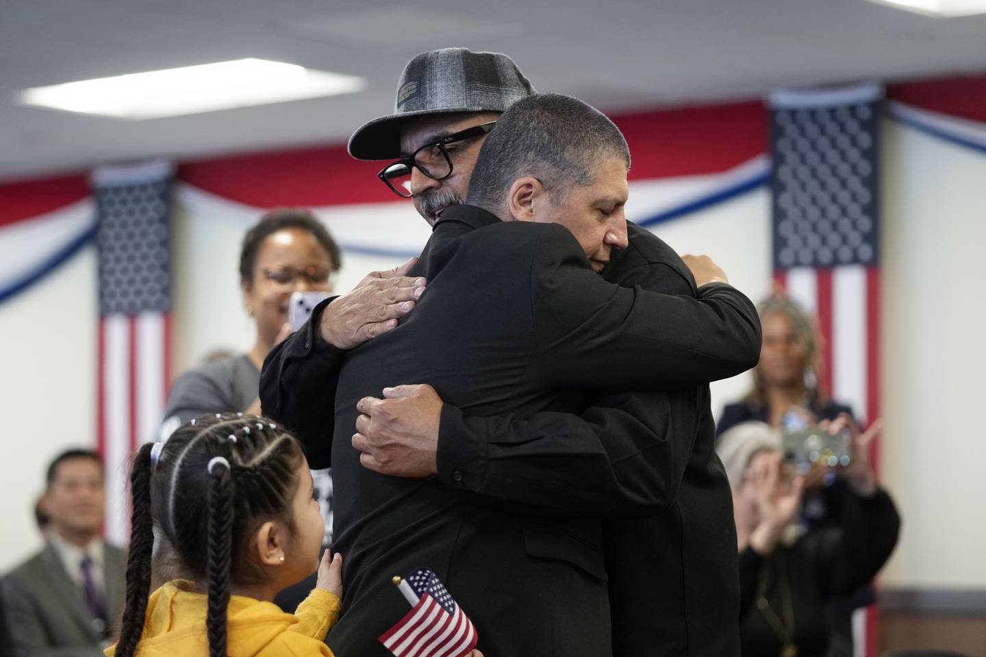 Deported veterans Mauricio Hernandez Mata, center right, and Leonel Contreras embrace after being sworn in as U.S. citizens at a special naturalization ceremony Wednesday, Feb. 8, 2023, in San Diego.