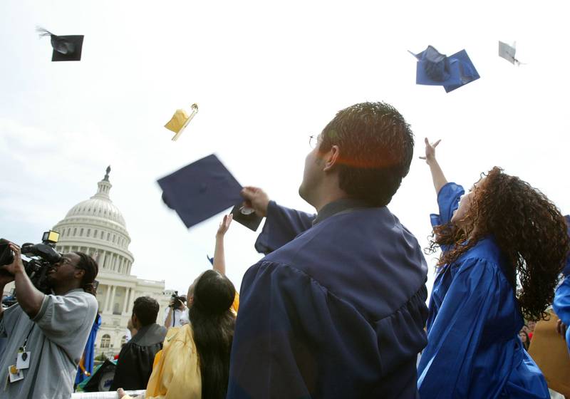 Students throw their caps during a mock graduation ceremony at the West Front of the U.S. Capitol April 20, 2004 in Washington, DC. (Photo by Alex Wong/Getty Images)