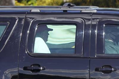 President Donald Trump rides in a motorcade vehicle as he departs Trump International Golf Club, Sunday, Dec. 27, 2020, in West Palm Beach, Fla.