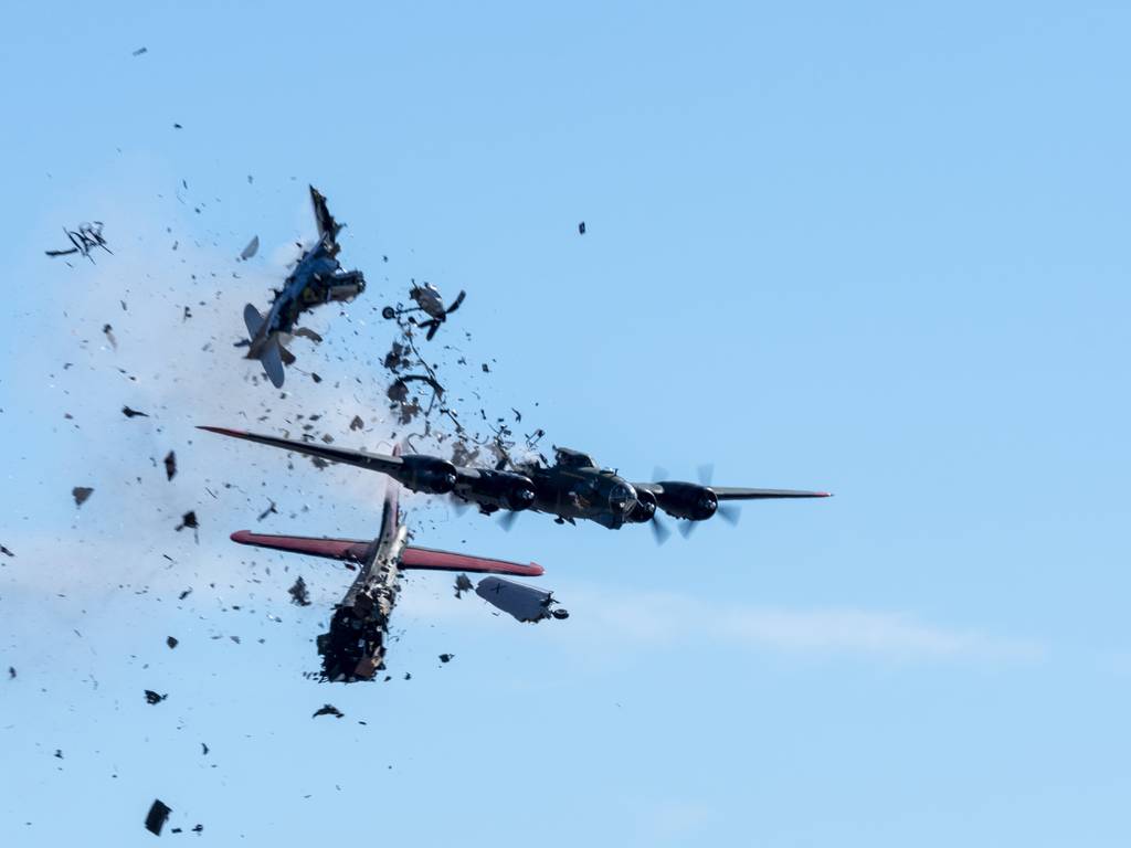 In this photo provided by Larry Petterborg, a Boeing B-17 Flying Fortress and a Bell P-63 Kingcobra collide in the midair during an airshow at Dallas Executive Airport in Dallas, Saturday, Nov. 12, 2022.