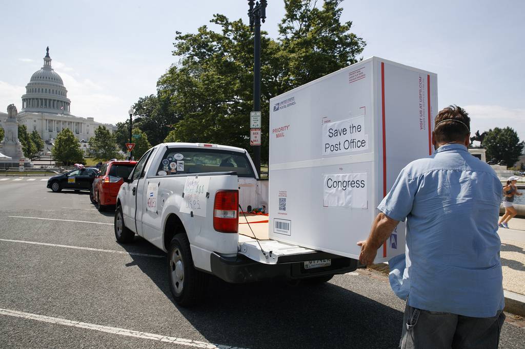 Paul Falcon unloads a custom made "Priority Mail" box that organizers said contained two million signed petitions from postal customers asking Congress to approve emergency funding for the Postal Service on June 23, 2020, on Capitol Hill in Washington.