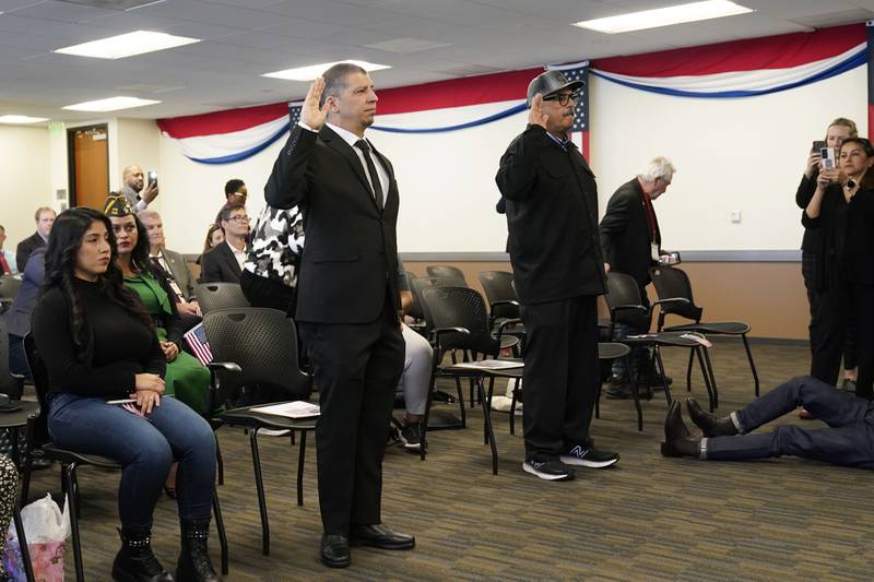 Deported veterans Mauricio Hernandez Mata, standing at left, and Leonel Contreras, standing at right, are sworn in as U.S. citizens at a special naturalization ceremony Wednesday, Feb. 8, 2023, in San Diego.
