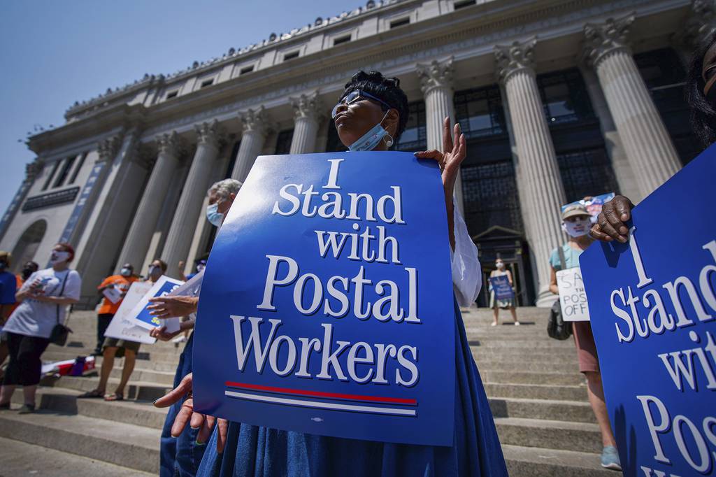 Retired postal worker Glenda Morris protests postal cutbacks, Tuesday, Aug. 25, 2020, in New York.
