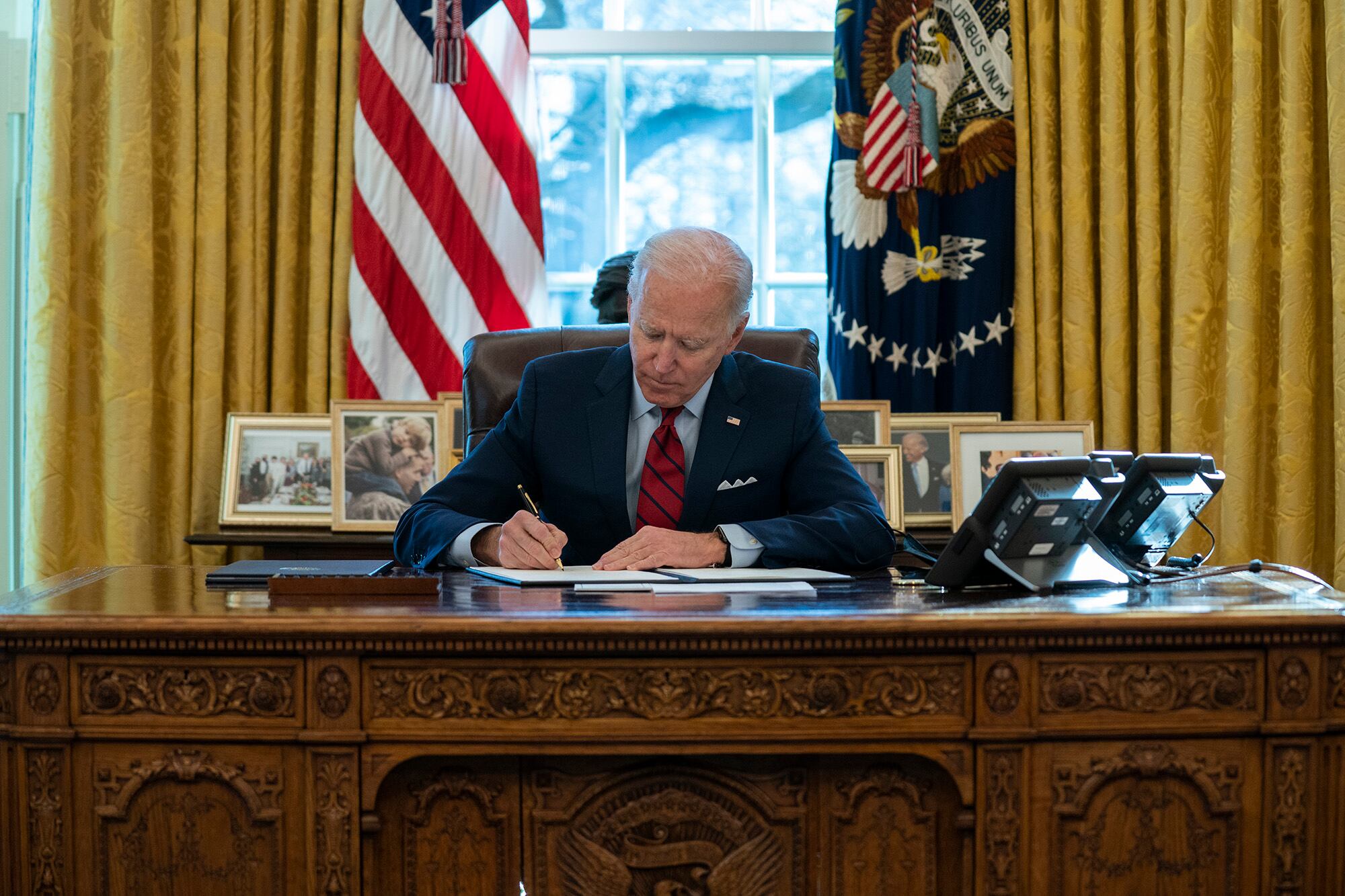 In this Jan. 28, 2021, file photo President Joe Biden signs a series of executive orders on health care, in the Oval Office of the White House in Washington.