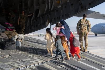 U.S. Air Force loadmasters and pilots load passengers aboard a U.S. Air Force C-17 Globemaster III in support of the Afghanistan evacuation at Hamid Karzai International Airport, Afghanistan, Aug. 24, 2021.